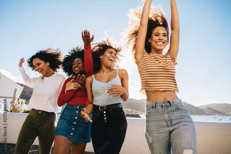 A multi-racial group of girls on a beach in the sun
