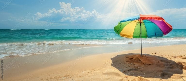 A multi-coloured beach umbrella on an empty beach - protect your skin from UV
